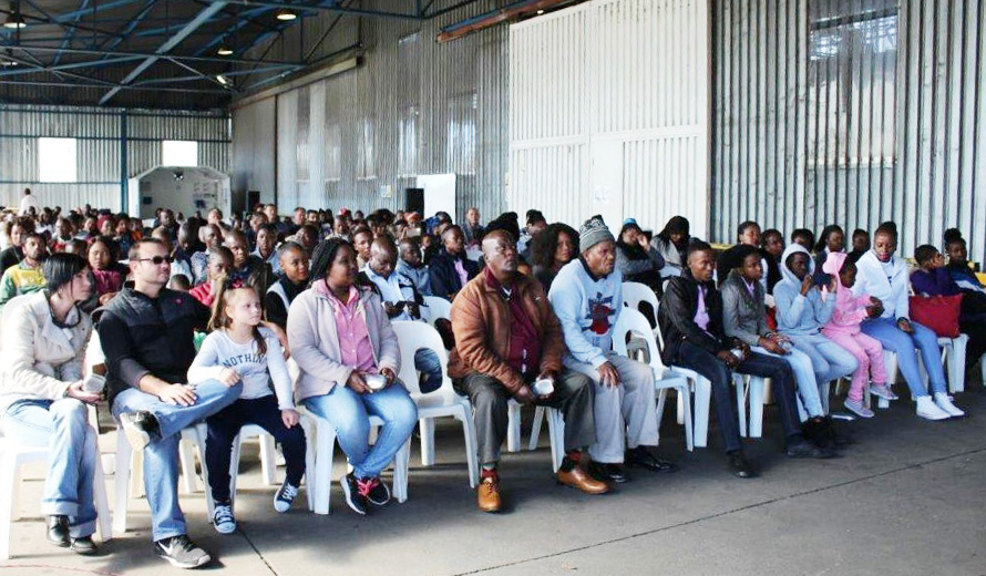 Employees and their families listen to introductory speech on safety.